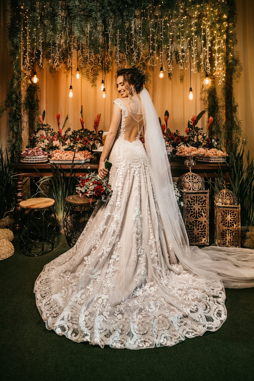 woman in white wedding dress standing beside red roses