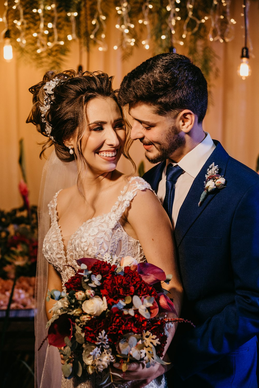 woman in white wedding dress holding bouquet of red roses