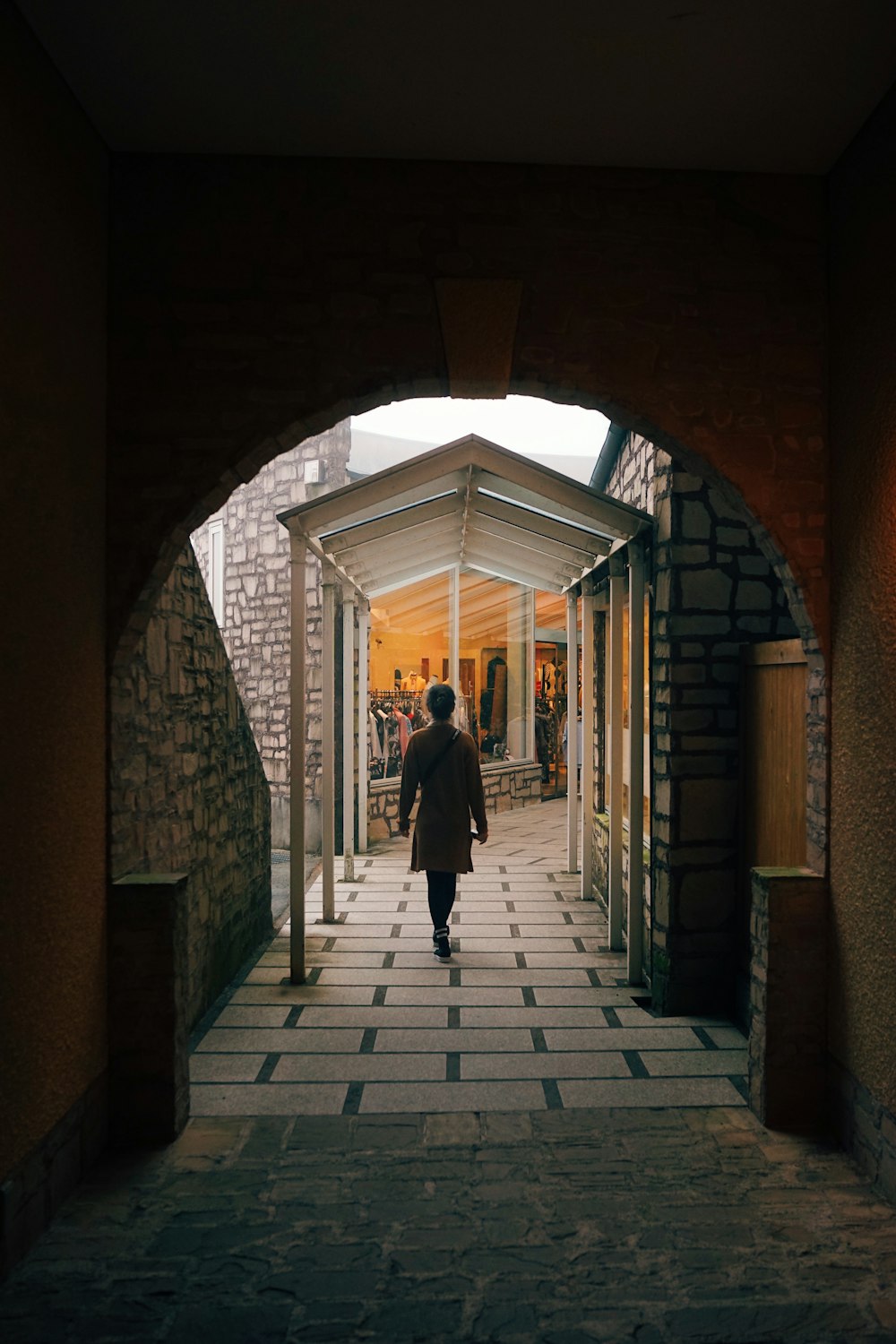 man in black jacket walking on sidewalk during daytime