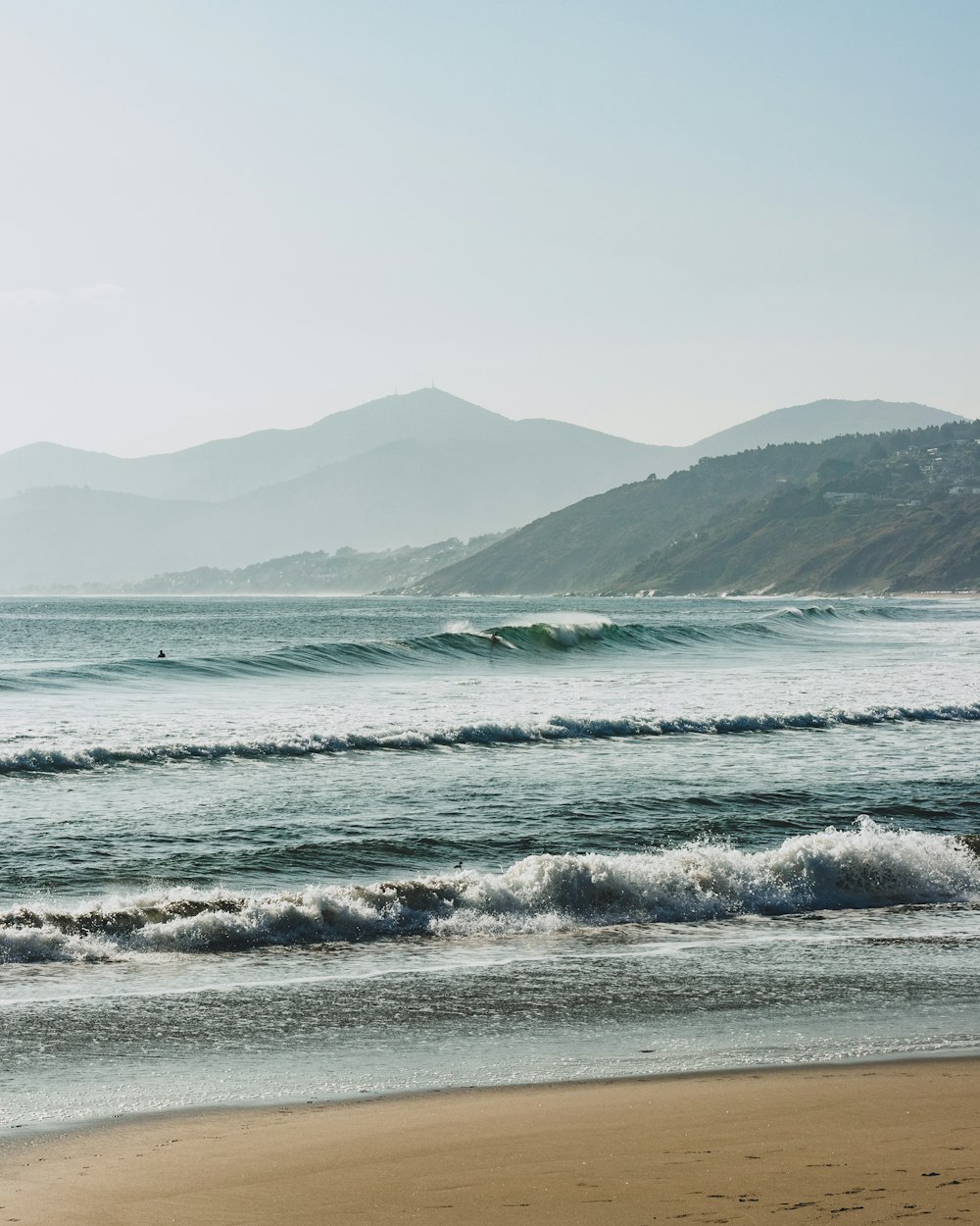 sea waves crashing on shore during daytime