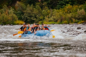 people riding on blue kayak on river during daytime