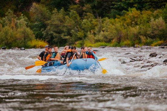 people riding on blue kayak on river during daytime
