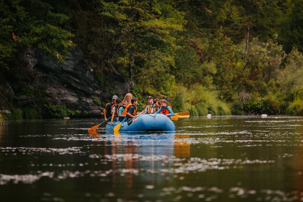 people riding on blue kayak on river during daytime