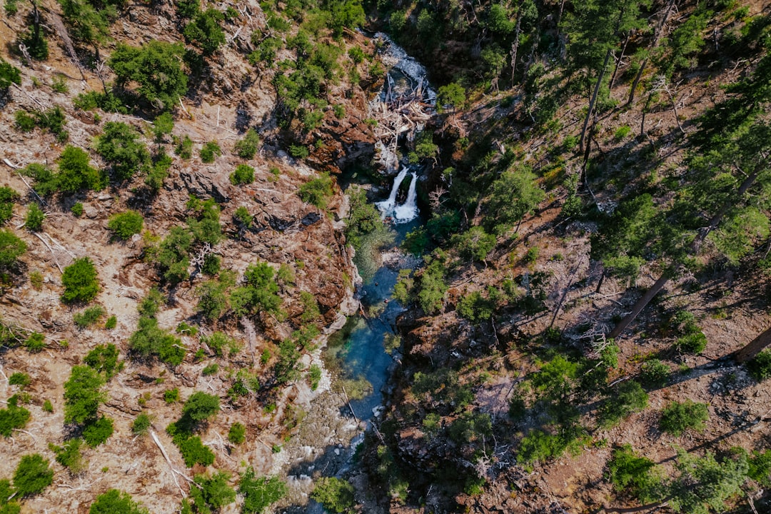 river in between green and brown rocky mountain during daytime