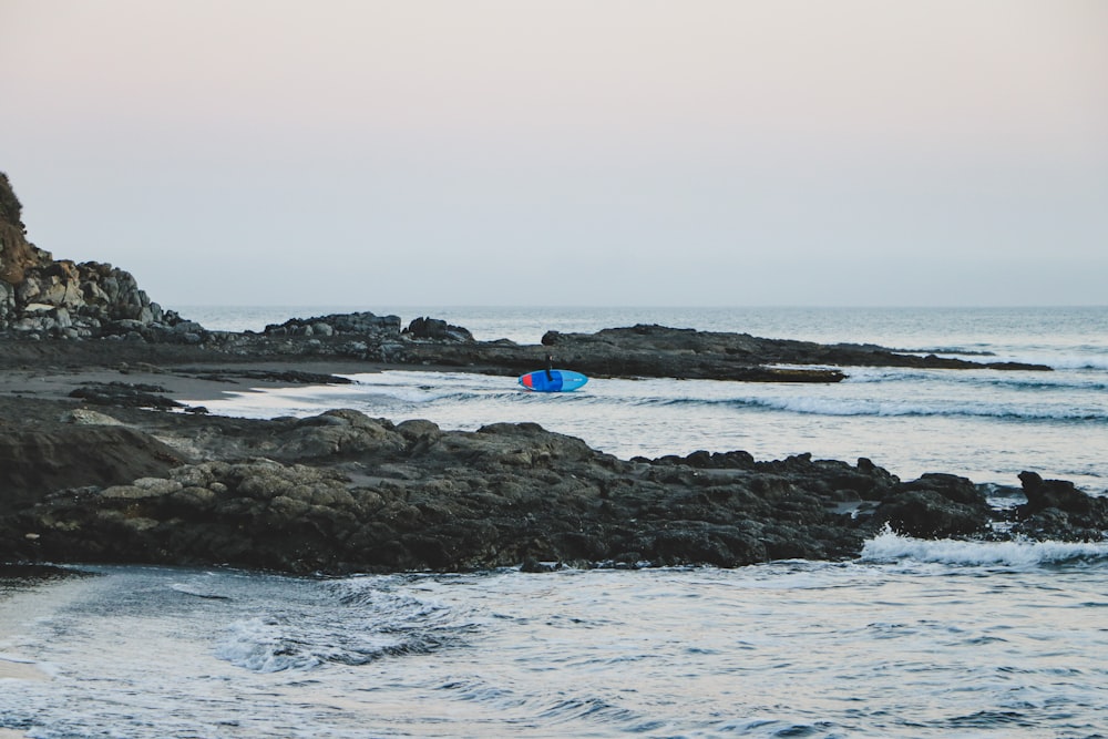 blue kayak on sea during daytime