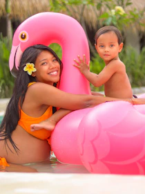 Children and parents enjoying a sunny day swimming in a sparkling blue pool.