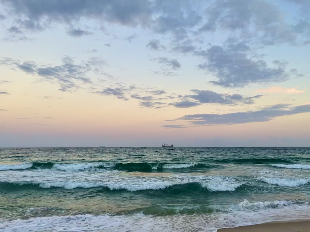 ocean waves under cloudy sky during daytime