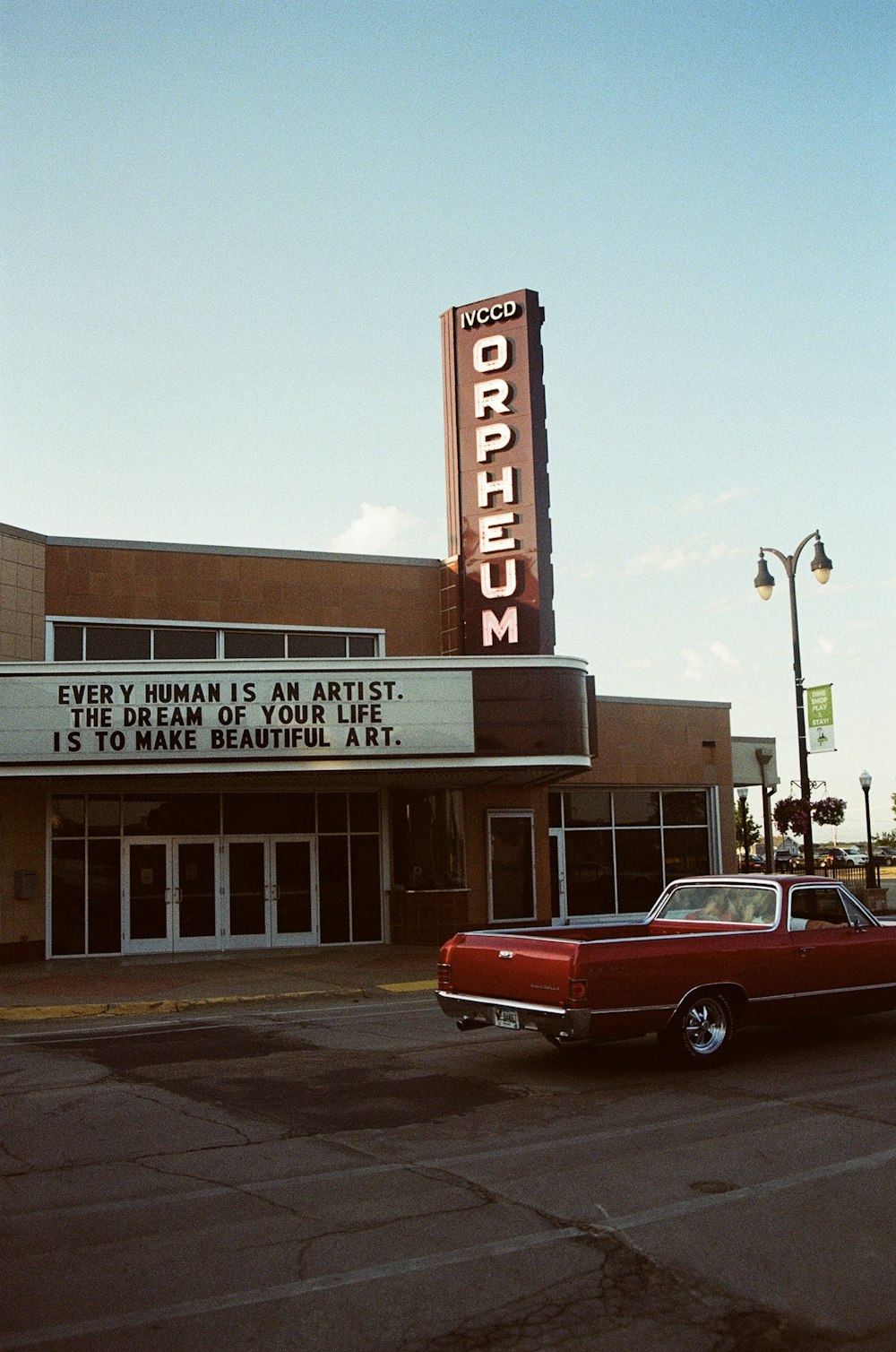a red car parked in front of a theater