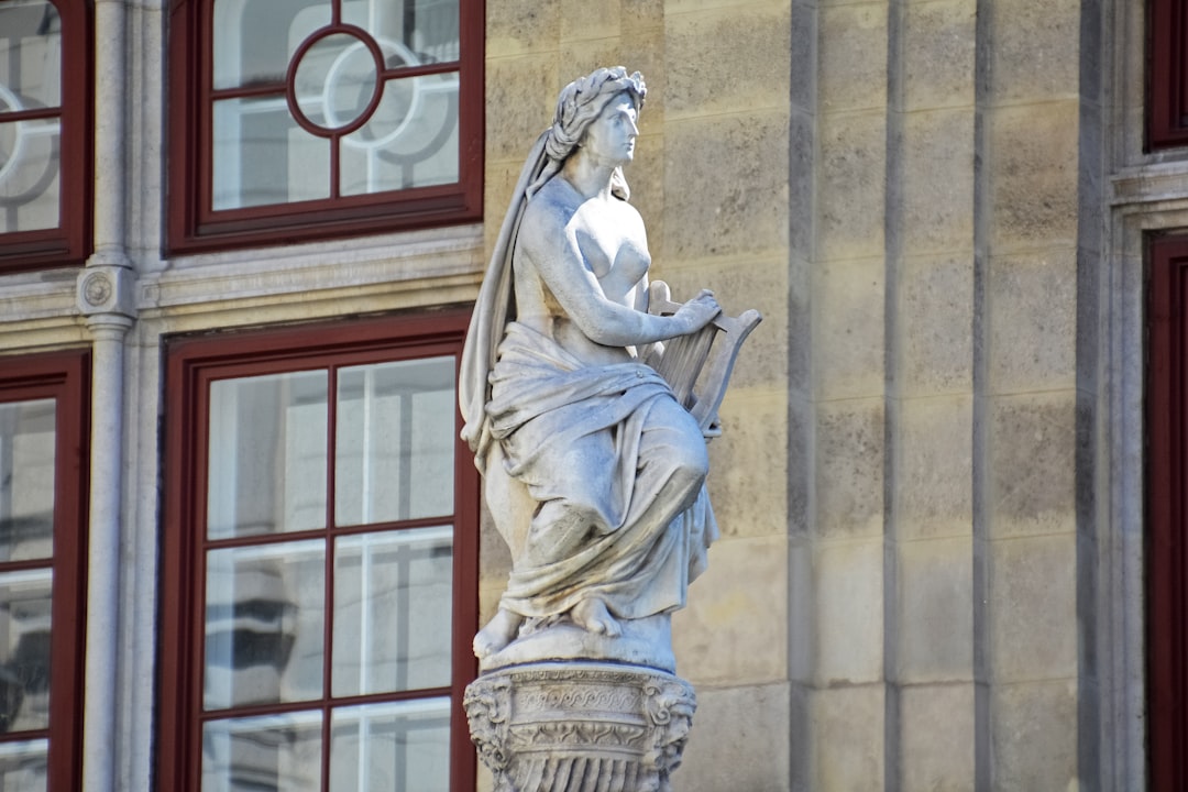 woman in dress statue near brown building