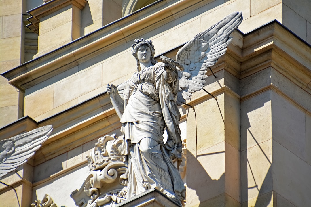 angel statue in front of beige concrete building