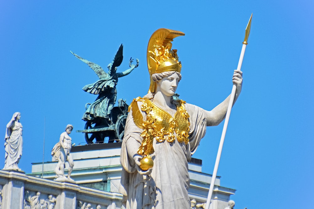 gold and white statue of a man holding a sword