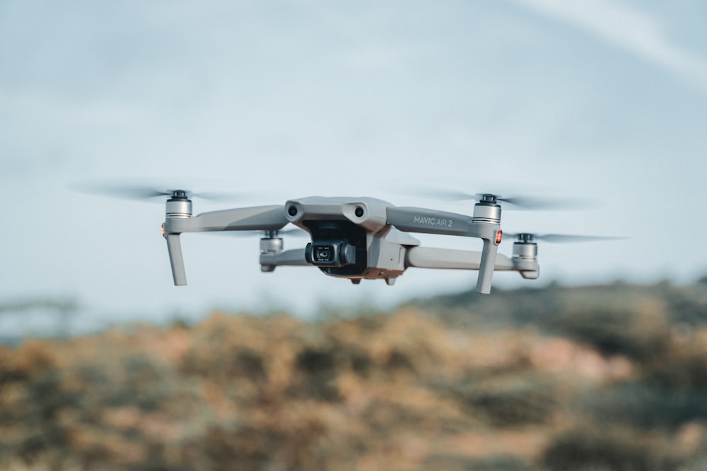 white drone flying in the sky during daytime