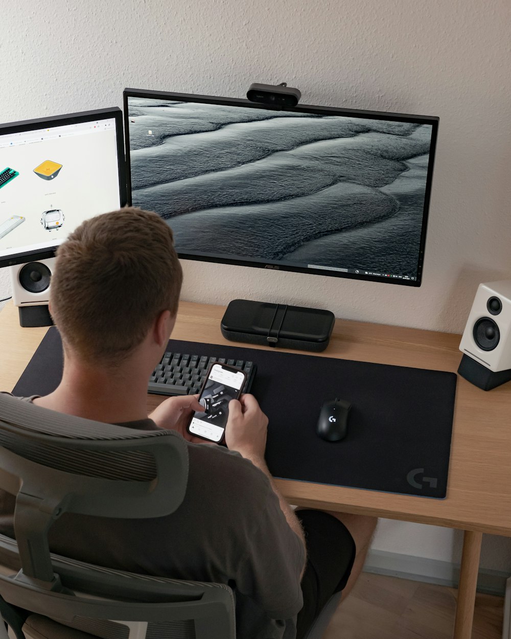 man in gray crew neck t-shirt sitting on chair in front of silver imac