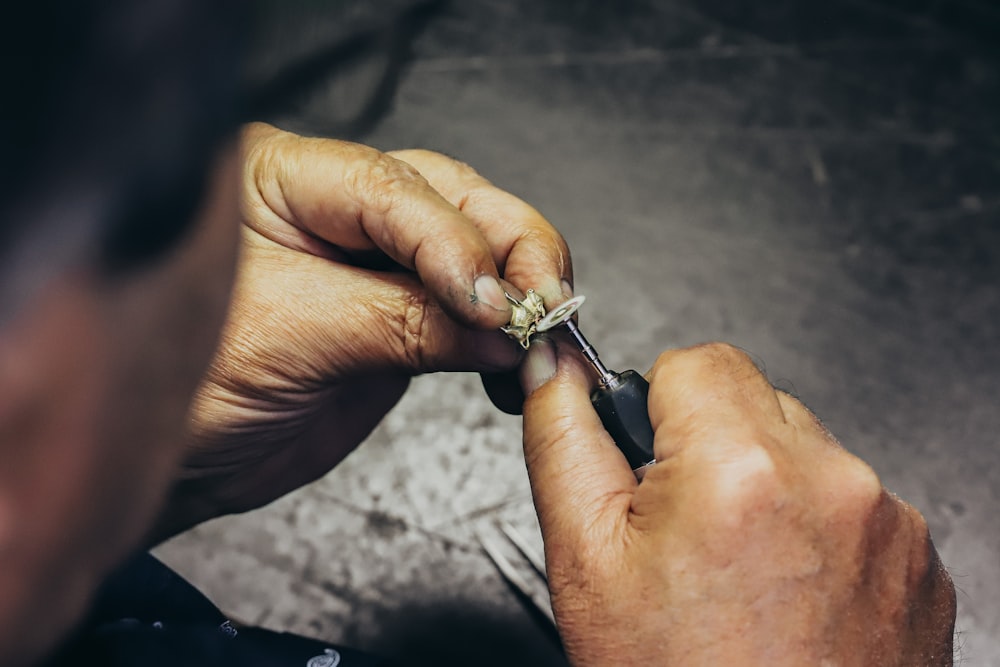 person holding silver and black hand tool