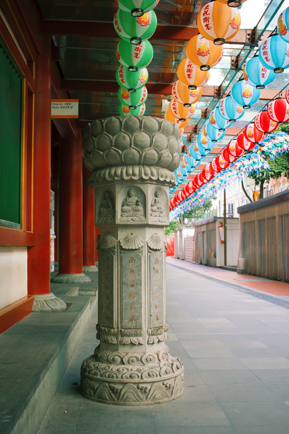 gray concrete post with red green and yellow lanterns on top