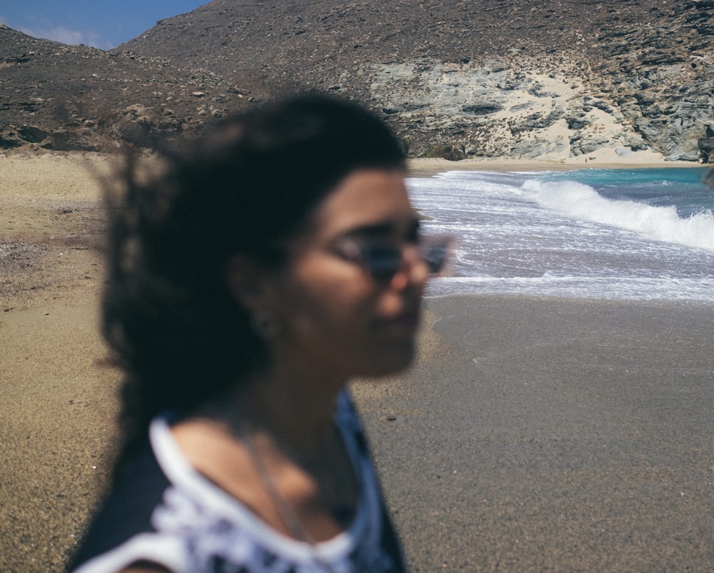 woman in white and black shirt standing on beach during daytime