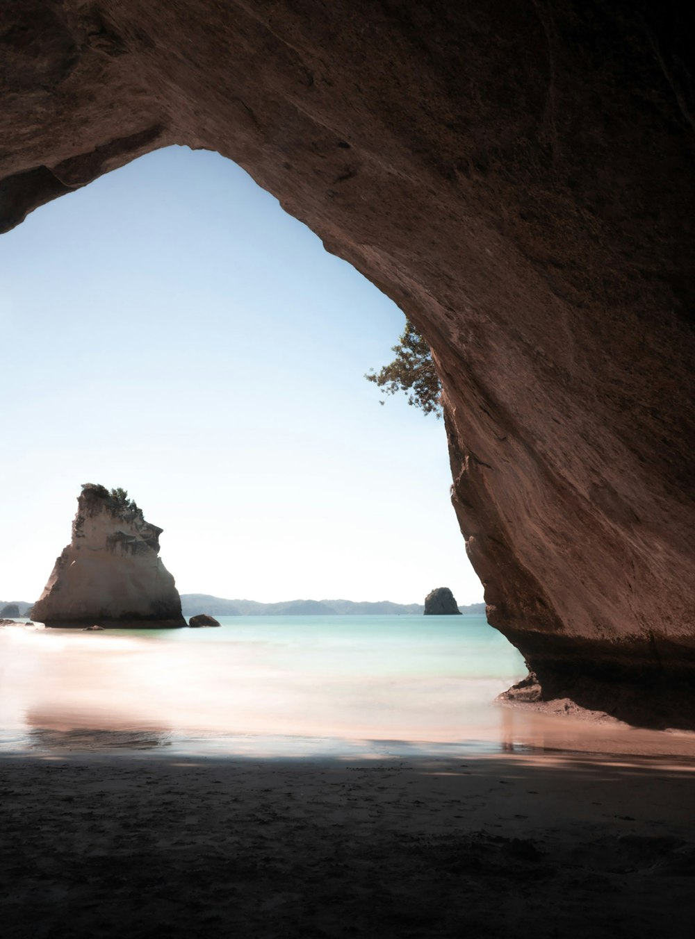 brown rock formation near body of water during daytime