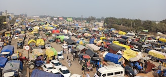 A panoramic view of a busy urban street with multiple trucks displaying diverse brand advertisements.
