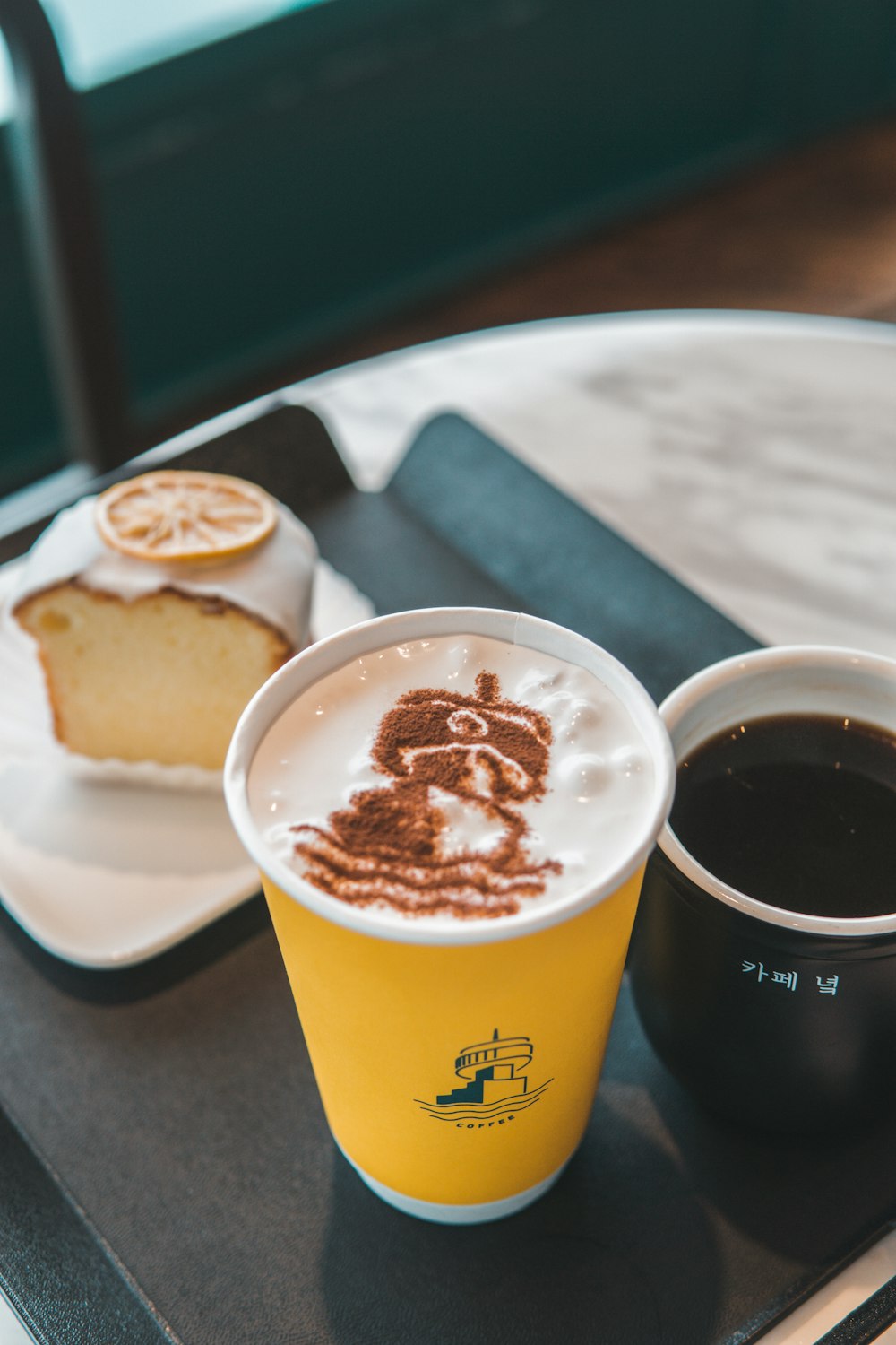 yellow and white disposable cup with coffee