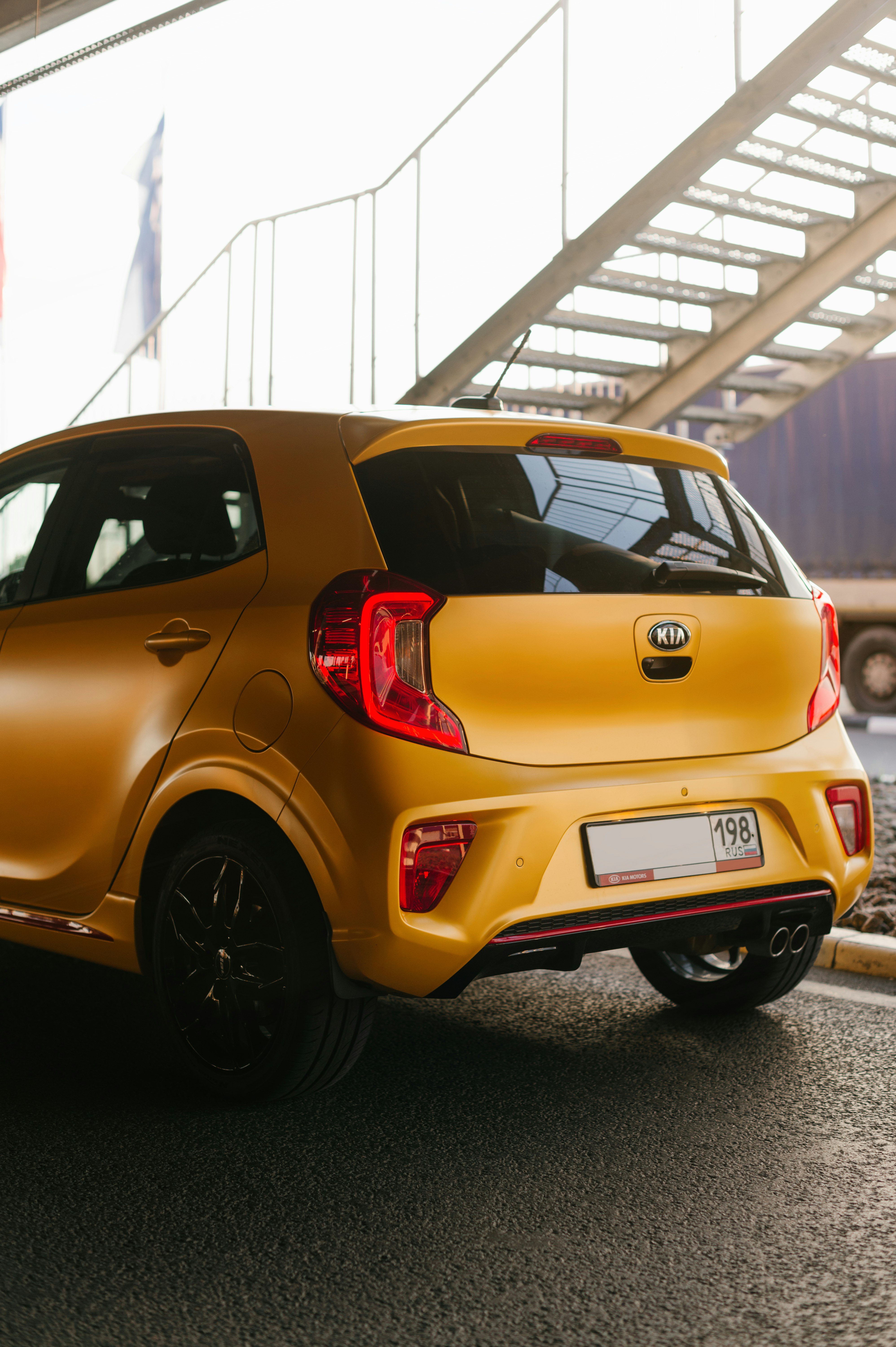 yellow 5 door hatchback parked on garage