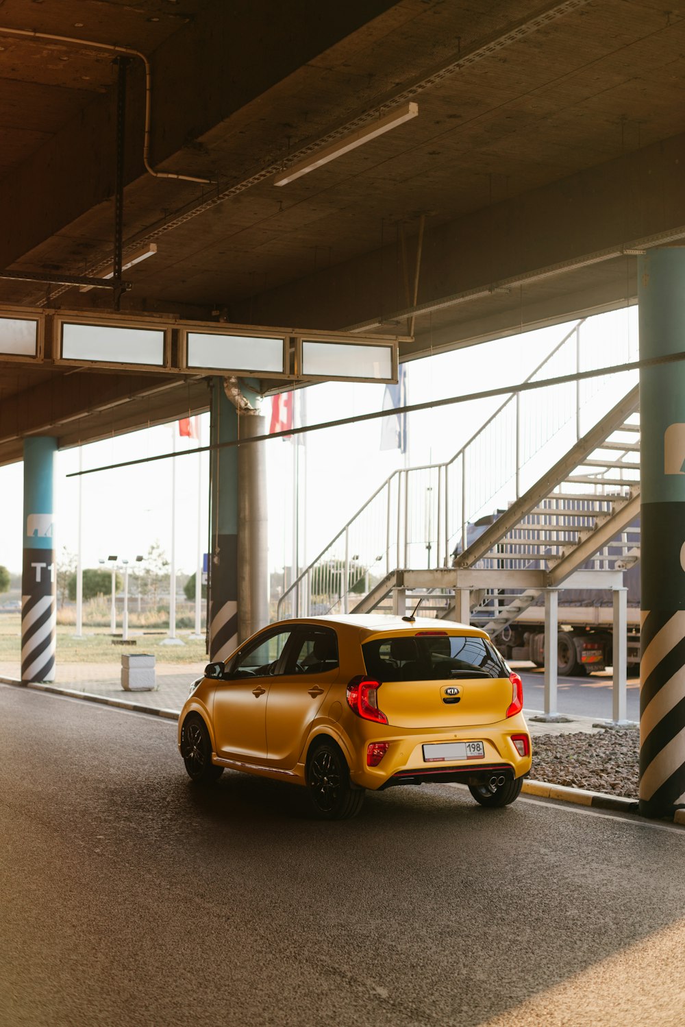 yellow sedan parked in front of white and black stripe building