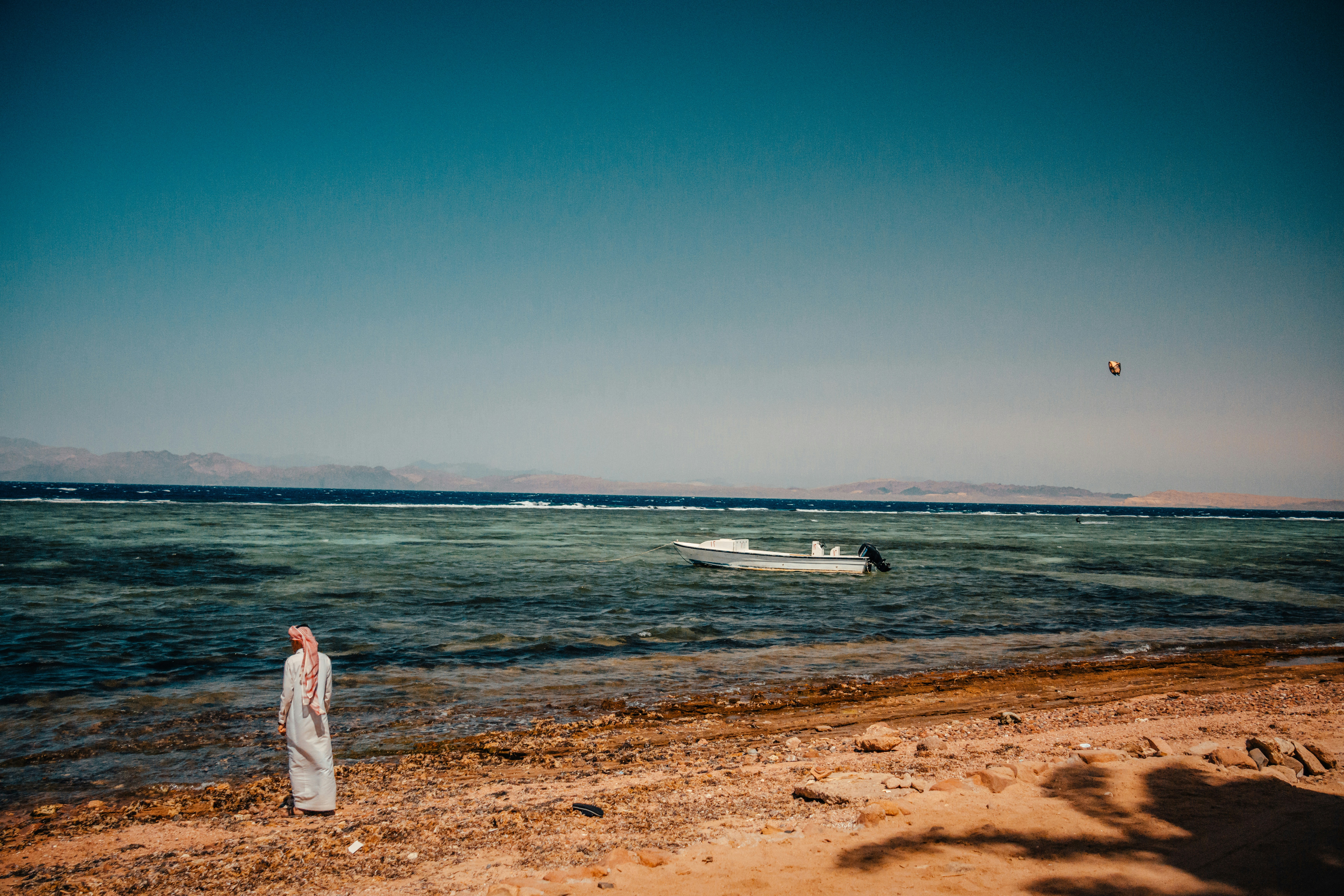 woman in white dress standing on beach during daytime, beduin at sea coast