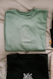 green crew neck shirt on white textile
