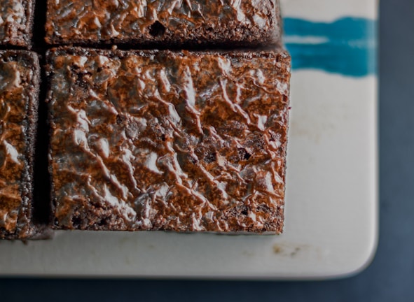 Close-up of a rich chocolate brownie with a glossy ganache topping.