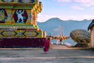 people walking on street near red and yellow temple during daytime