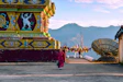 people walking on street near red and yellow temple during daytime