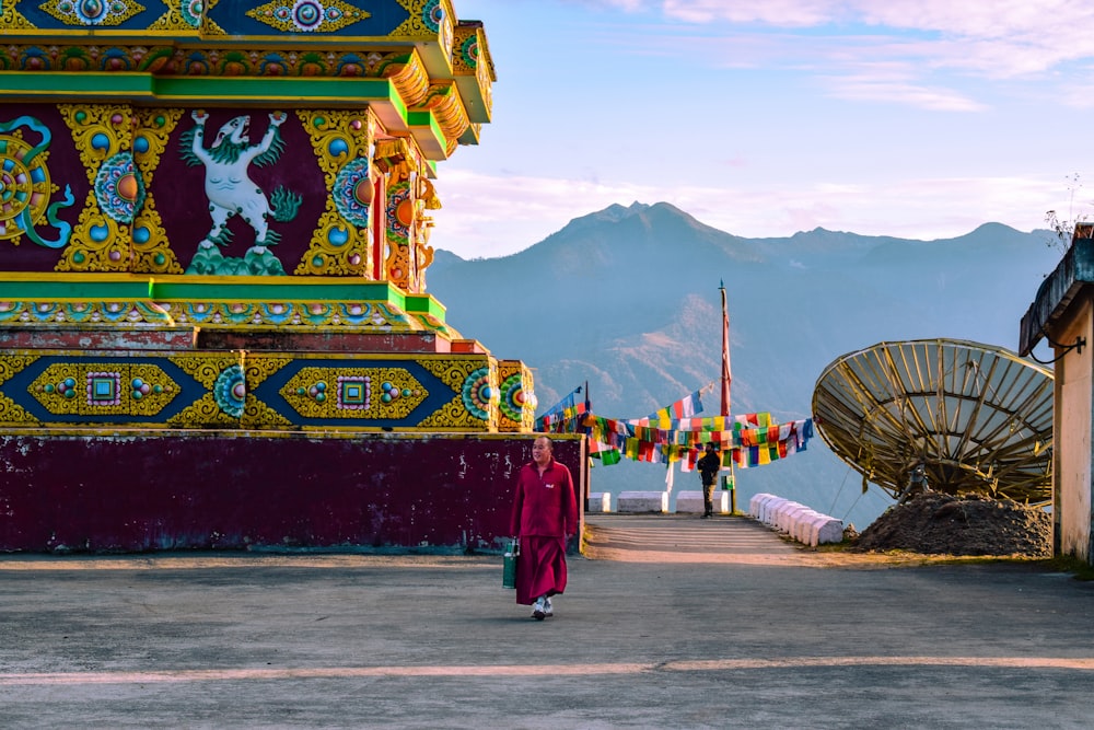 people walking on street near red and yellow temple during daytime