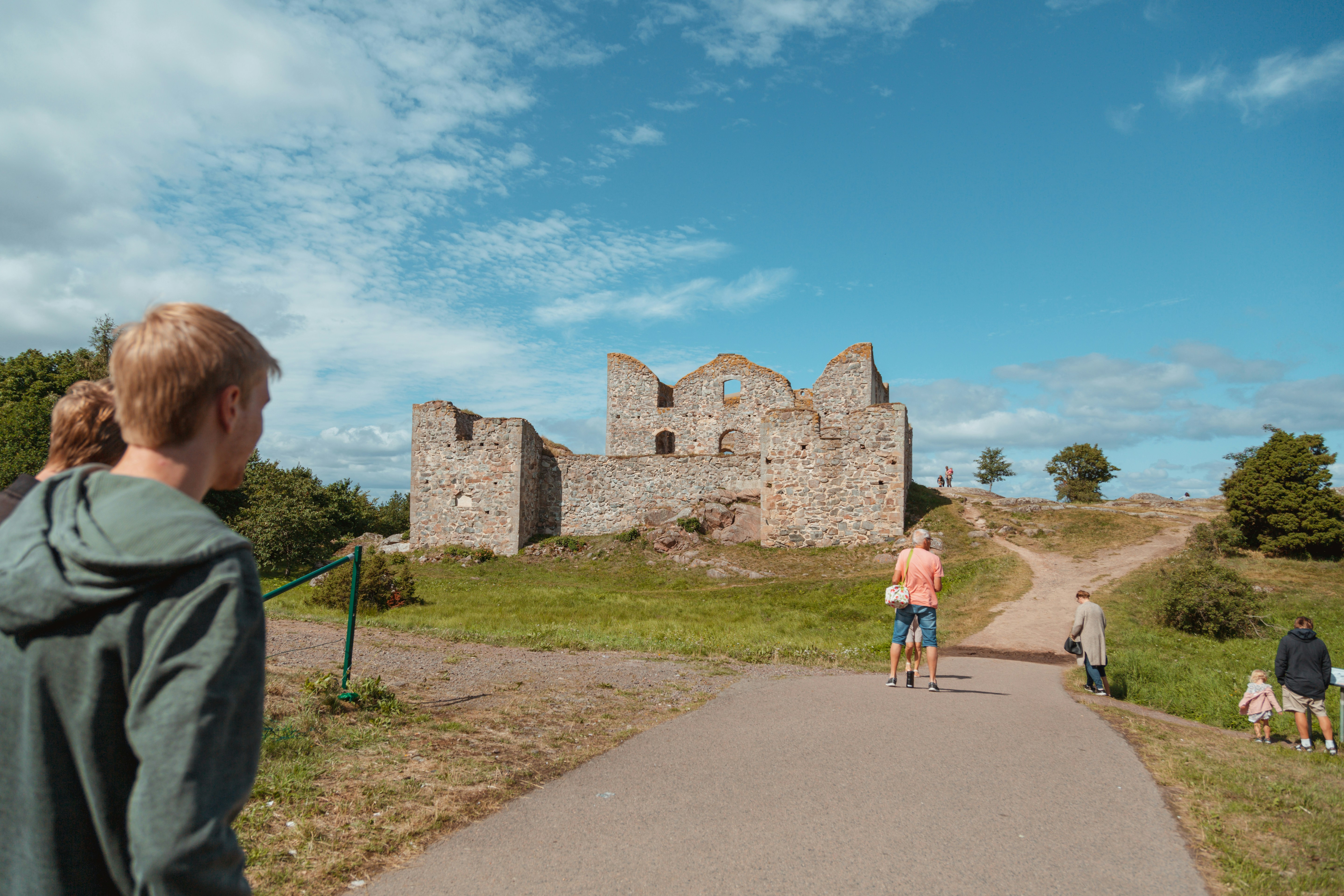 people walking on gray concrete pathway near brown concrete building during daytime