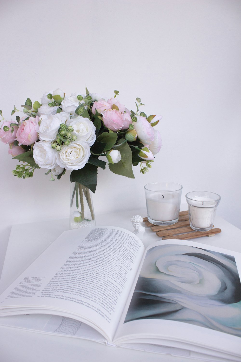 white and purple flowers in clear glass vase on brown wooden table