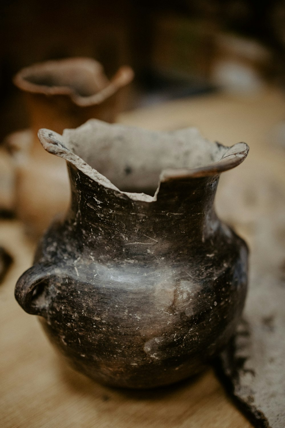 brown ceramic vase on brown textile