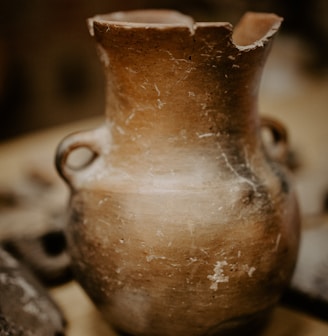 brown ceramic vase on black and white textile