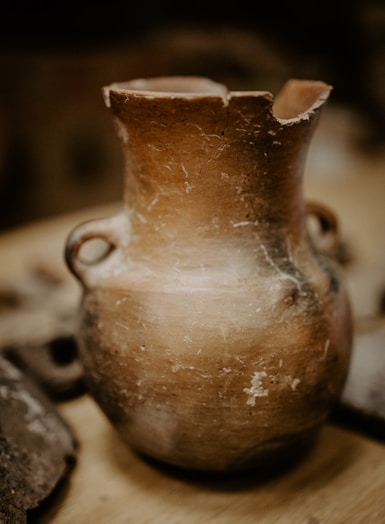 brown ceramic vase on black and white textile