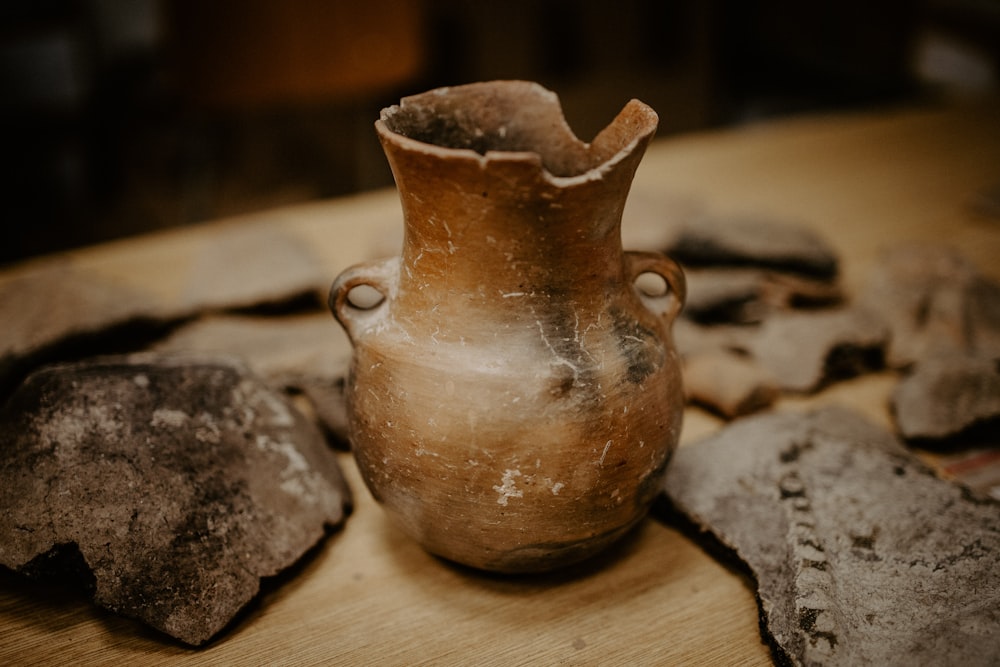 vaso in ceramica marrone su tavolo in legno marrone