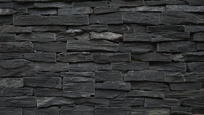 Dark black slate stones stacked neatly, highlighting their texture.