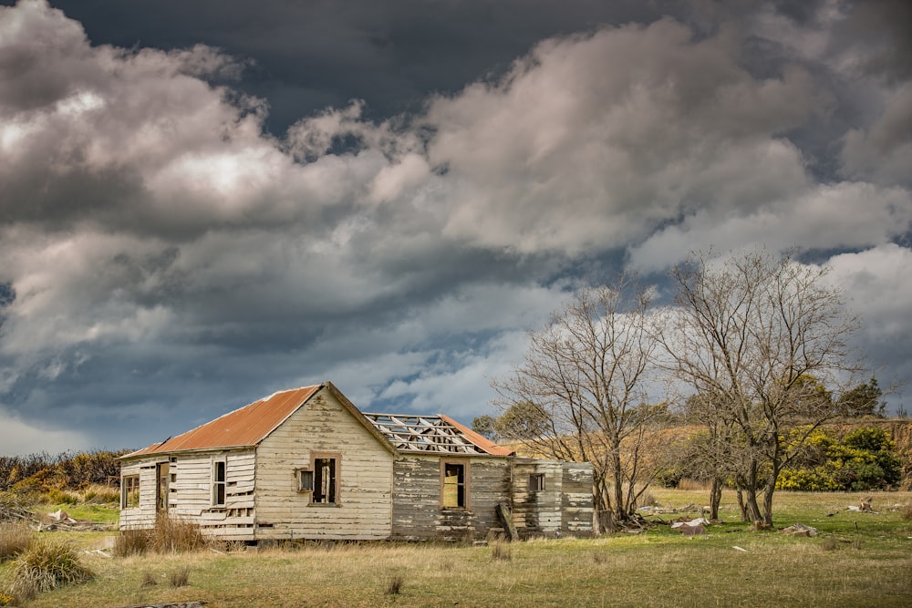 brown and white wooden house under gray clouds