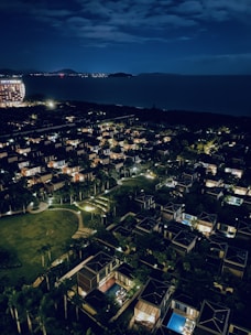 Night view of a residential complex illuminated near the sea.