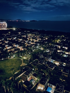 Night view of a residential complex illuminated near the sea.