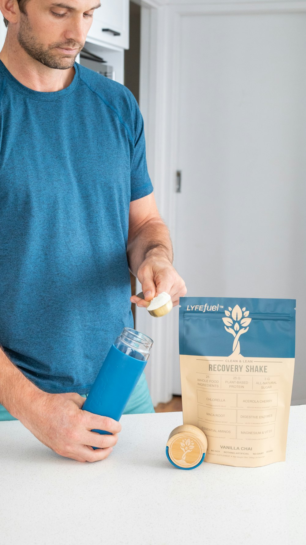 man in blue crew neck t-shirt holding blue and white plastic bottle