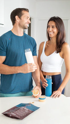 man in blue crew neck t-shirt holding woman in white tank top
