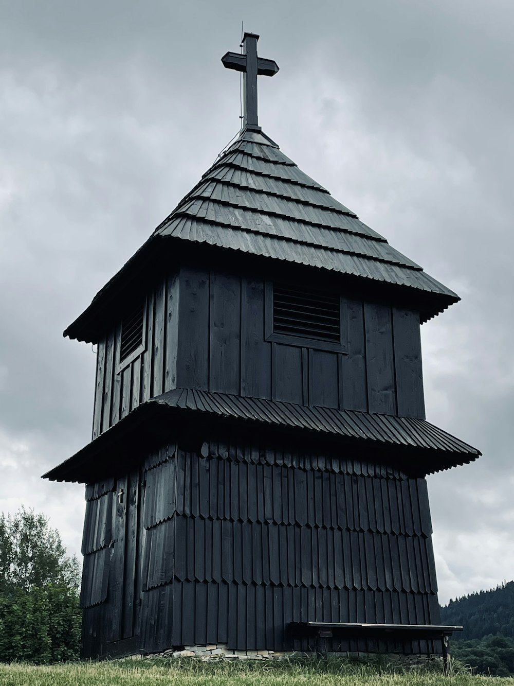 black wooden house near green trees during daytime