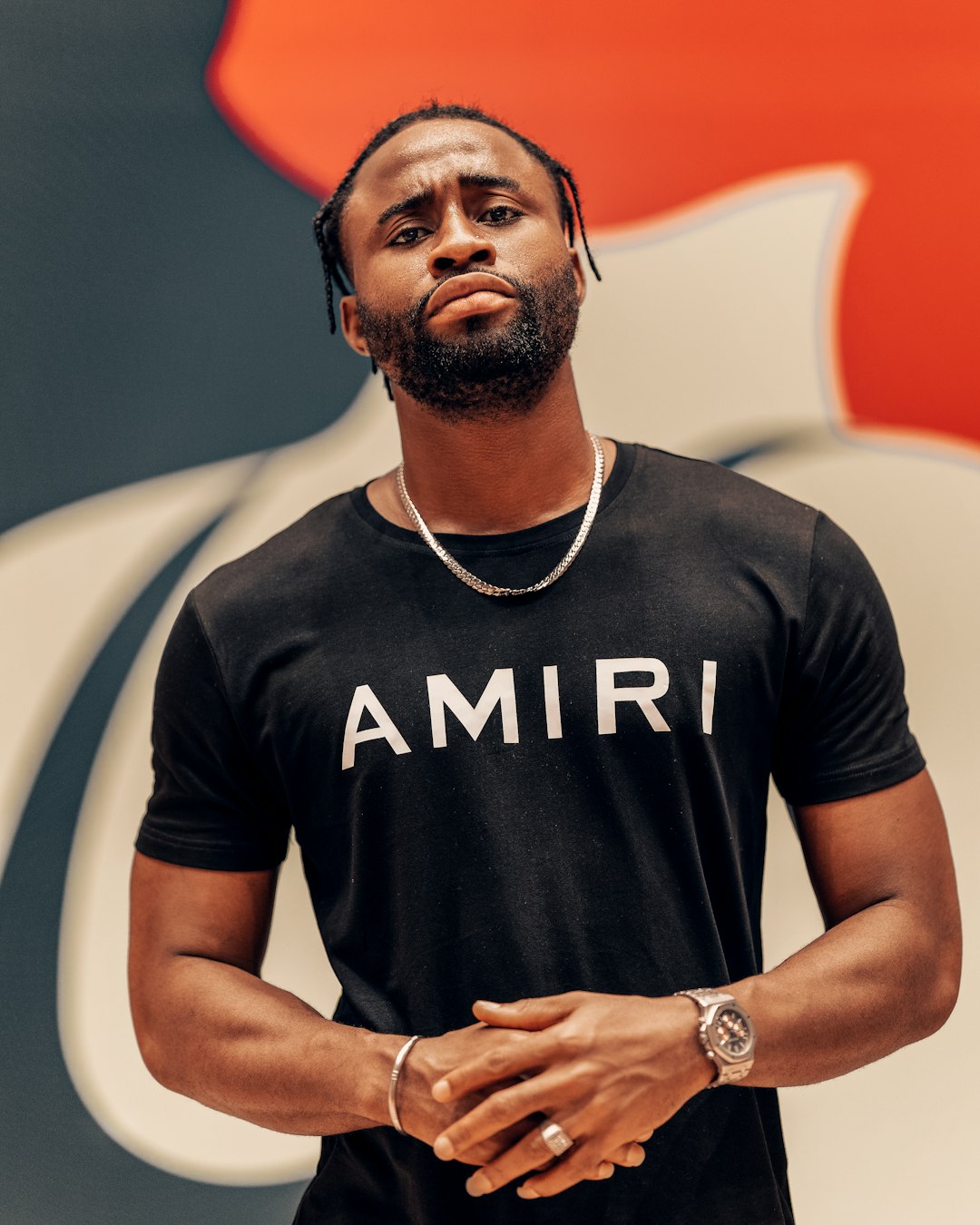 man in black crew neck t-shirt wearing silver link bracelet round watch