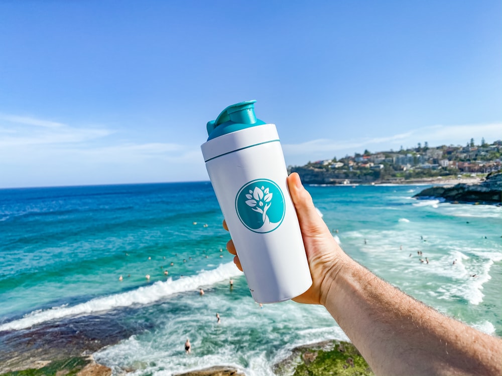 person holding white and blue plastic cup