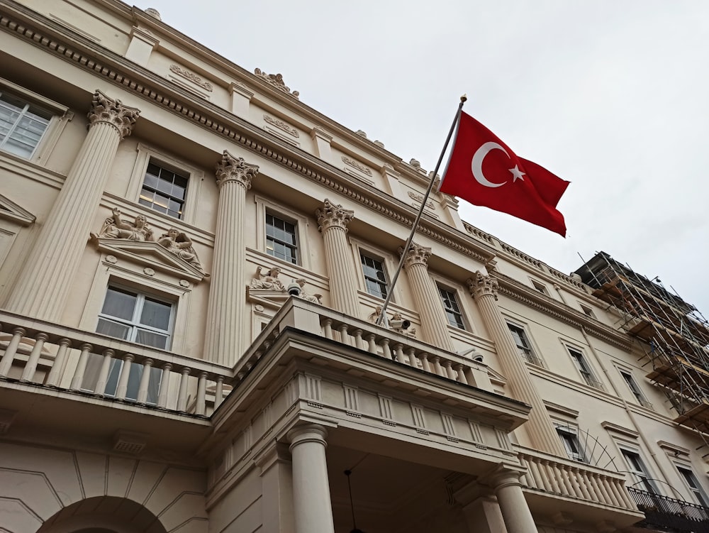 Edificio de hormigón beige con bandera roja