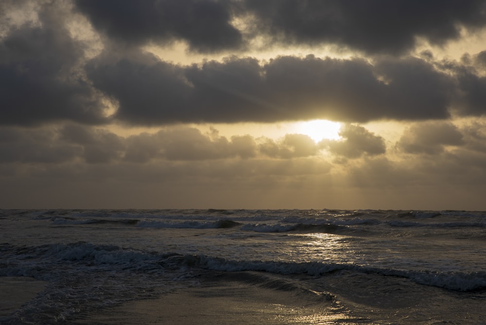 ocean waves under cloudy sky during daytime