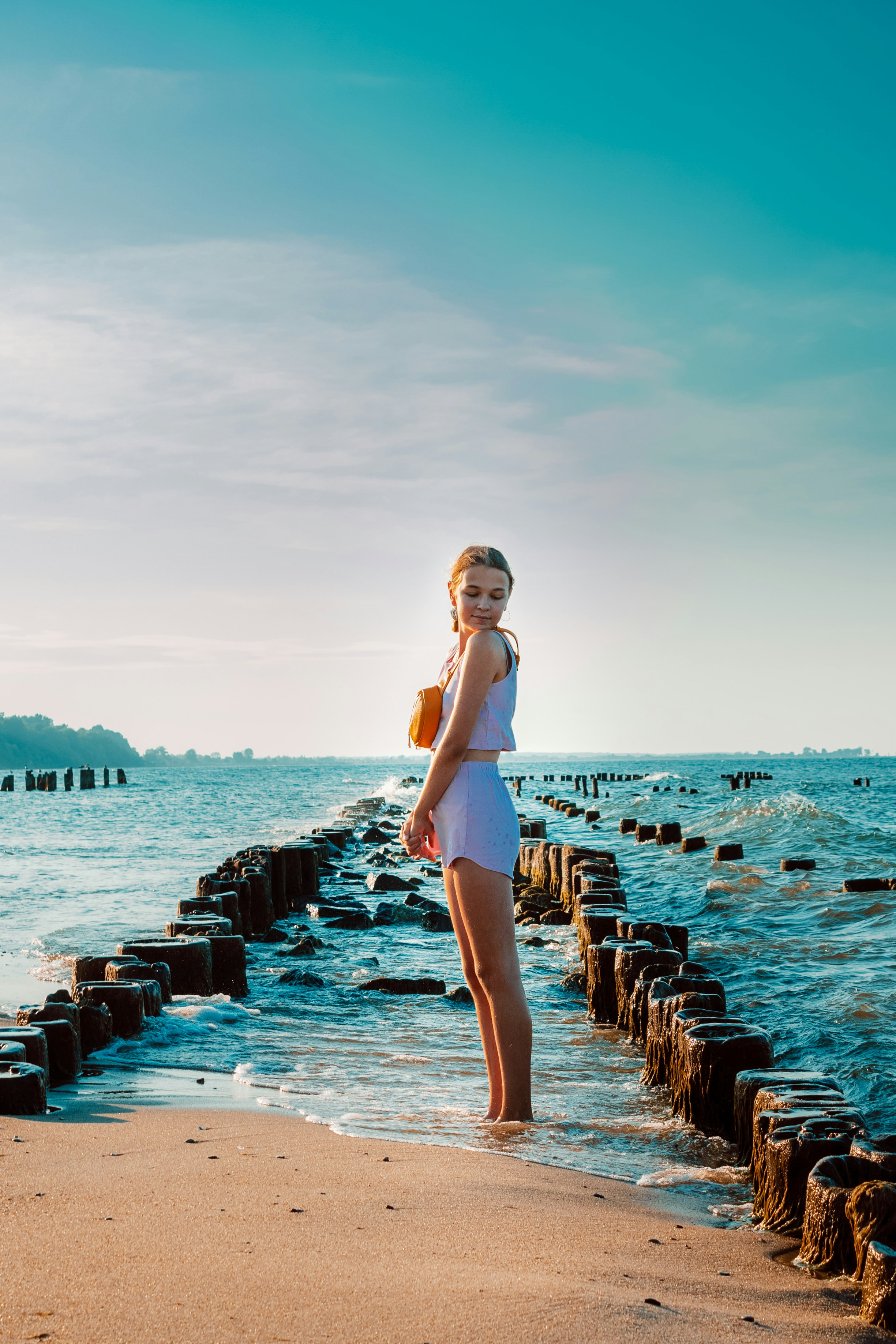girl standing in the sea while sunset