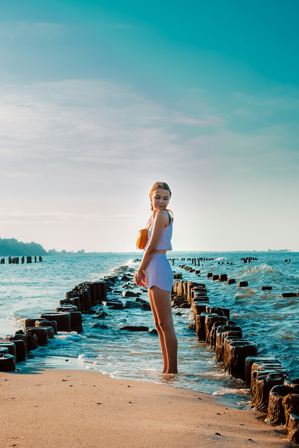 woman in white dress standing on dock during daytime